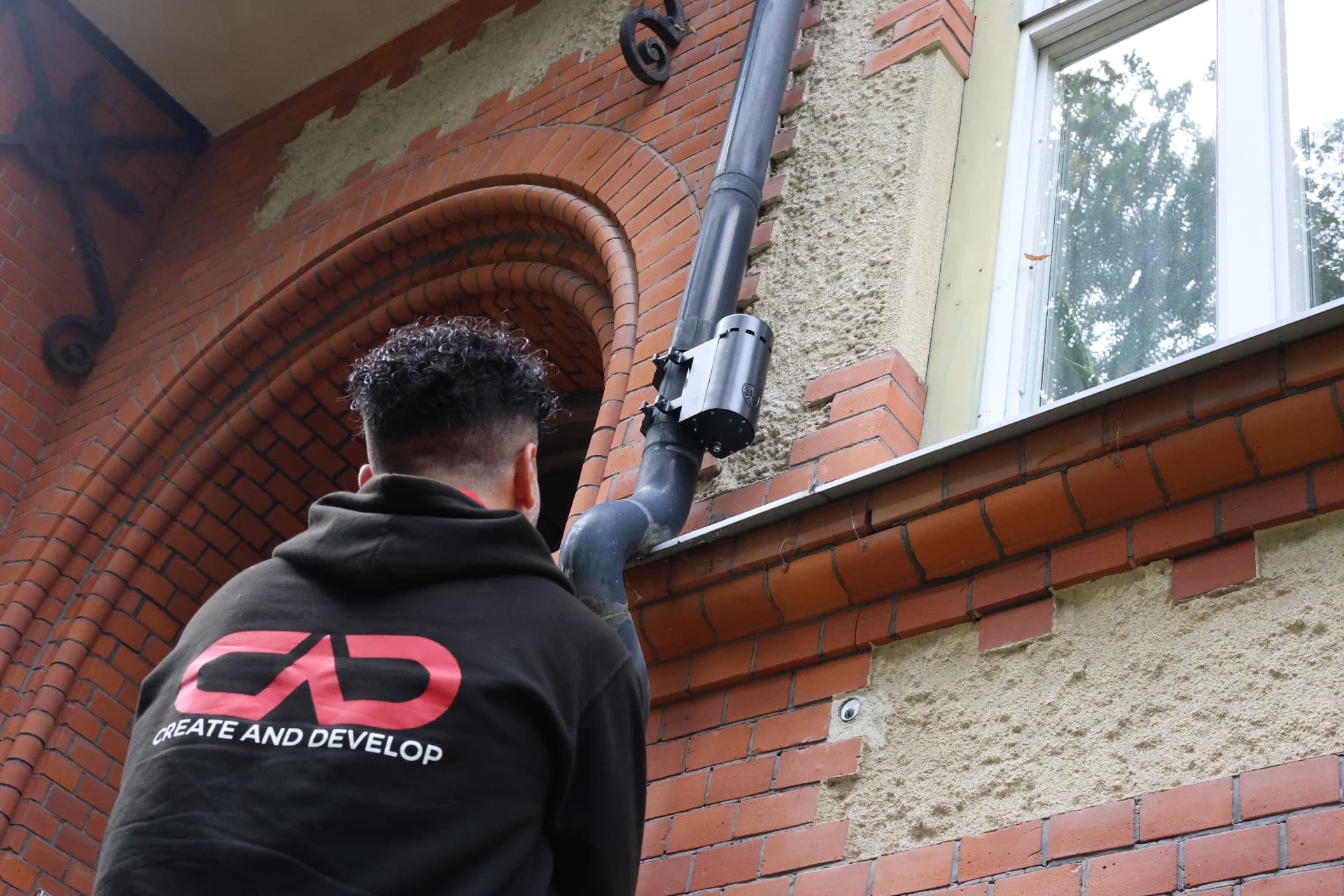 Tekniker från CAD – Create And Develop installerar IceGuard på ett stuprör